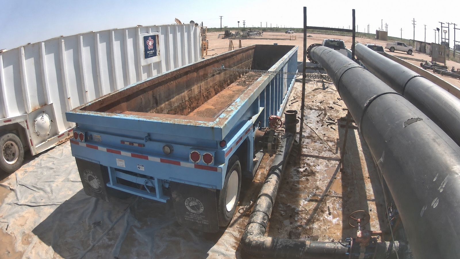 A transfer trailer and containment area at a produced water site.
